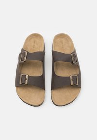 Sandați maro cu două curele ajustabile cu catarame, talpă interioară asemănătoare cu suedeul și talpă din cauciuc conturată. Design minimalist fără accente suplimentare.