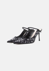 Črne slingback petke z ostrim nosom, satensko površino, okrasno pentljo in srebrnim zakovicami na zgornjem delu. Visoka stiletto peta.