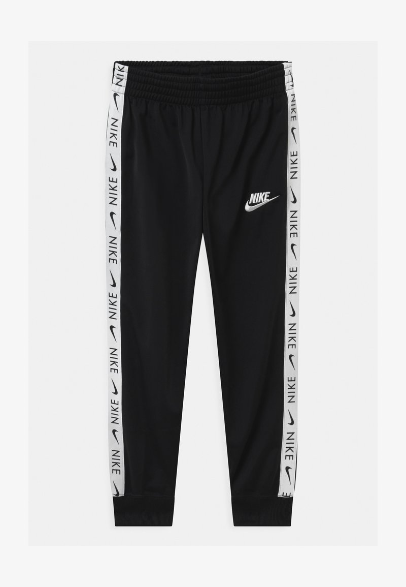 Pantalones deportivos negros hechos de una tela elástica, con una cinturilla elástica, puños en los bajos y franjas laterales blancas con la marca "NIKE".
