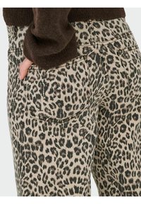 Farmerice s uzorkom leoparda od denima, s bež podlogom i crnim i smeškim mrljama. Imaju stražnje džepove i kontrastne šavove.
