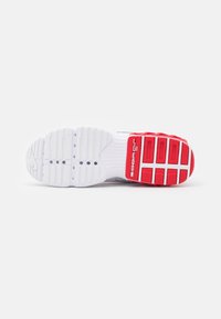 Kenka ousole yang terbuat dari bahan karet, terutama berwarna putih, memiliki aksen merah. Pola tekstur mencakup alur melingkar dan horizontal.
