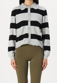 Harmaa neuletakki mustilla raidoilla, nappikiinnitys, kuperakauluskanta ja helma. Valmistettu pehmeästä materiaalista, pitkähihaisena.