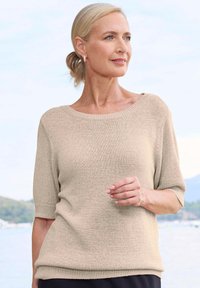 Beige gebreide trui met korte mouwen, een brede halslijn en een textuurstof. Het heeft een losse pasvorm en een geribbelde zoom.