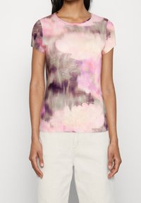 Kortärmad topp i ett blommönster med nyanser av rosa, lila och grått. Har en rund halslinning och en mjuk, len textur.
