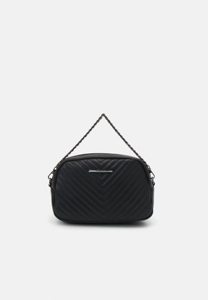 Czarna pikowana skórzana torebka z wzorem w jodełkę i krótkim skręconym łańcuszkowym uchwytem na białym tle.