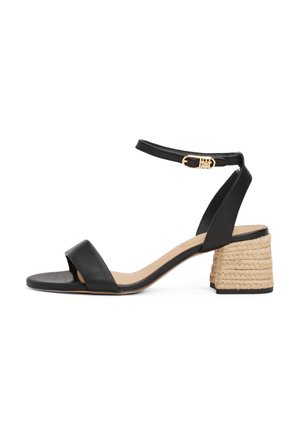 Black leather heeled sandals with a wide strap across the toe, ankle strap, and a braided jute block heel. Gold hardware detail on the strap.
