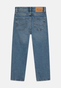 Lys blå denimbukser med rett passform, synlig søm, to baklommer og en gyllen læretikett på midjen.