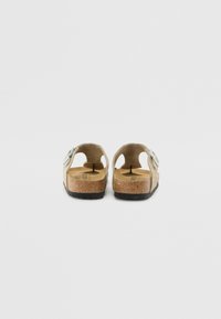 Mokka-suède sandalen met een kurken voetbed, achterbandjes en decoratieve blauwe bloemen, voorzien van uitsparingen voor ventilatie en een getextureerde zool.