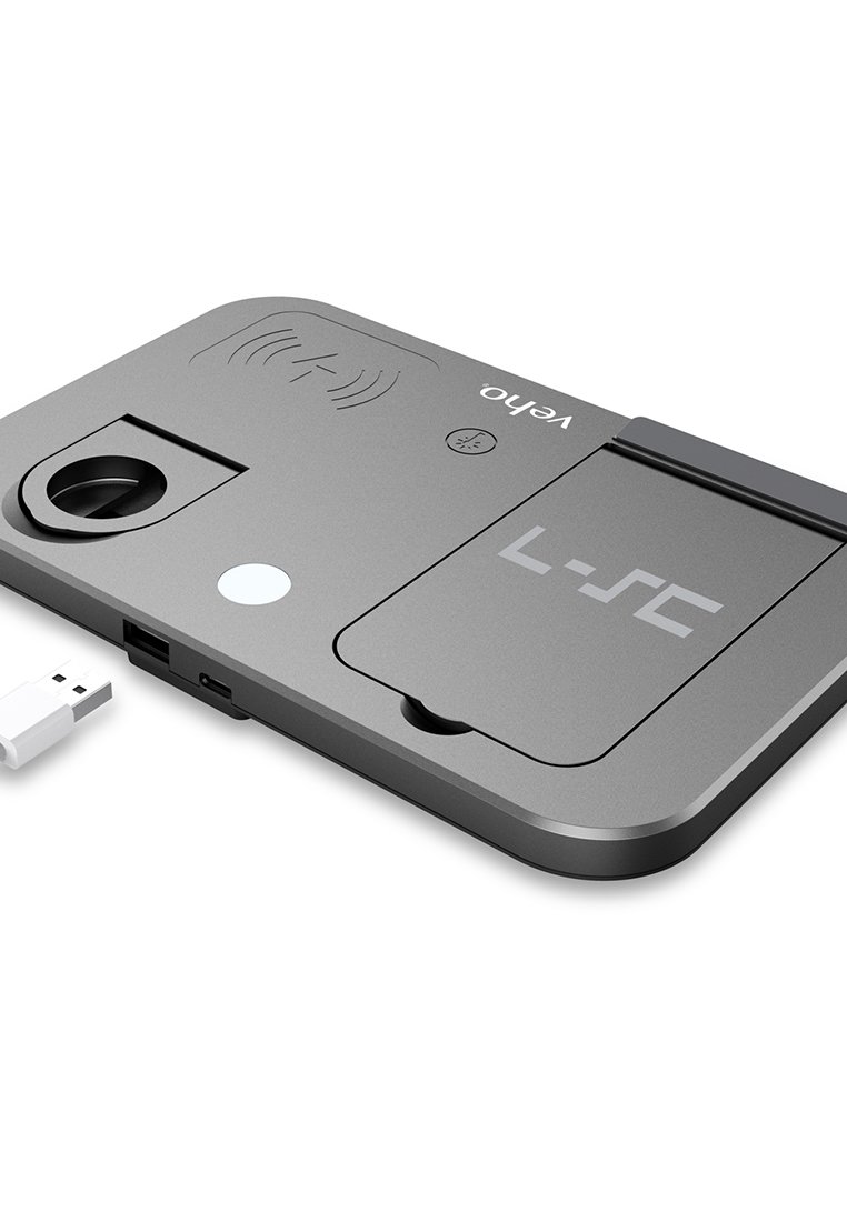 Grauer Ladepad mit runder Vertiefung, USB-Anschluss und Symbol für drahtloses Laden. Verfügt über eine Schiebedeckel und ein minimalistisches Design.