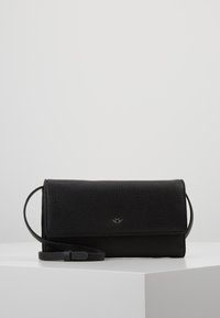 Borsa a tracolla in pelle nera texturizzata con chiusura a pattina e tracolla sottile regolabile, mostrata su superficie bianca inclinata.