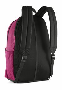Un sac à dos avec un devant en suède rose et un dos en mailles noires. Il est équipé de bretelles rembourrées, d'une poche latérale et d'une forme structurée. Matériaux durables.