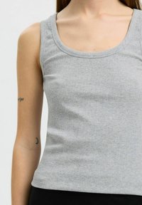 Débardeur côtelé gris clair avec un col rond et une coupe ajustée, fabriqué en tissu texturé doux, avec des bretelles étroites.