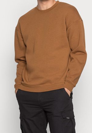 Sudadera marrón con cuello redondo y mangas largas, hecha de un suave material de algodón. Presenta un corte relajado y puños acanalados.