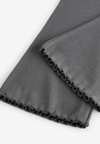 Grauer gerippter Stoff mit einer strukturierten Oberfläche, der voluminöse Kanten aufweist. Das Material ist weich und flexibel, ideal zum Schichten oder für den Komfort.