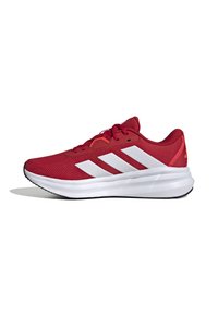 Red athletic shoe with mesh fabric upper, featuring white three-stripe design, padded collar, and a white midsole. Black rubber outsole.