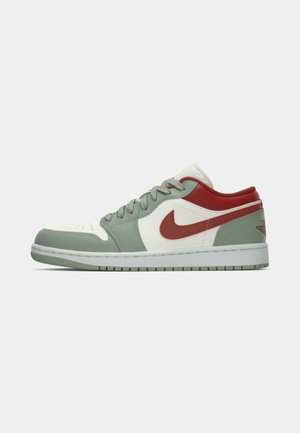 Niedrigschuh Sneaker aus grünem Wildleder, weißen Leder, rotem Nike-Swoosh und -Kragen, weißer Zwischensohle und grünem Gummiausgang.