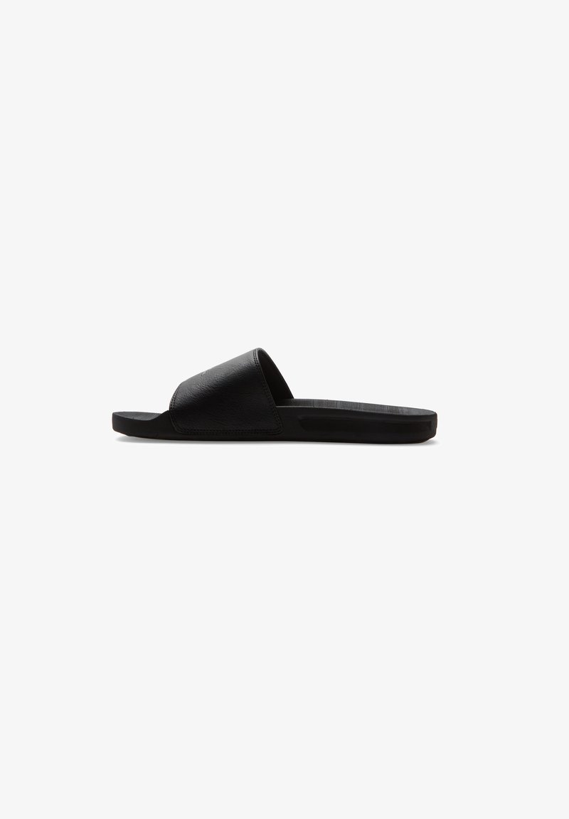 Black slide-on sandal made of textured synthetic material, featuring a single wide strap and a flat rubber sole. Simple and minimalistic design.