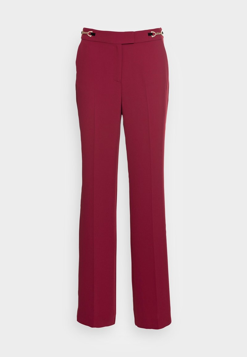 Pantalon droit bordeaux pour femme avec détail chaîne dorée à la taille, pli frontal et poches latérales.