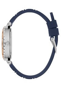 Silverfärgad klocka med en roséguldkant och rem av marinblå silikon, med en texturerad boett, metallelement och en böljande design.