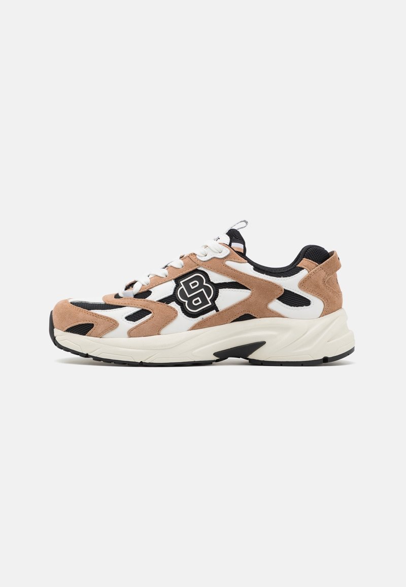 Baskets de sport blanches, noires et beiges avec détails en daim, lacets sur le devant et logo sur le côté, vues de profil sur un fond uni.
