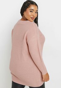 Helles rosa Strickpullover mit gerippter Textur, langen Ärmeln und lockerer Passform. Verfügt über einen weiten Ausschnitt und einen etwas längeren hinteren Saum.