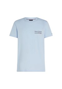 Camiseta de algodón en azul claro con cuello redondo y mangas cortas. Un pequeño logo impreso con texto se encuentra en el área del pecho izquierdo.