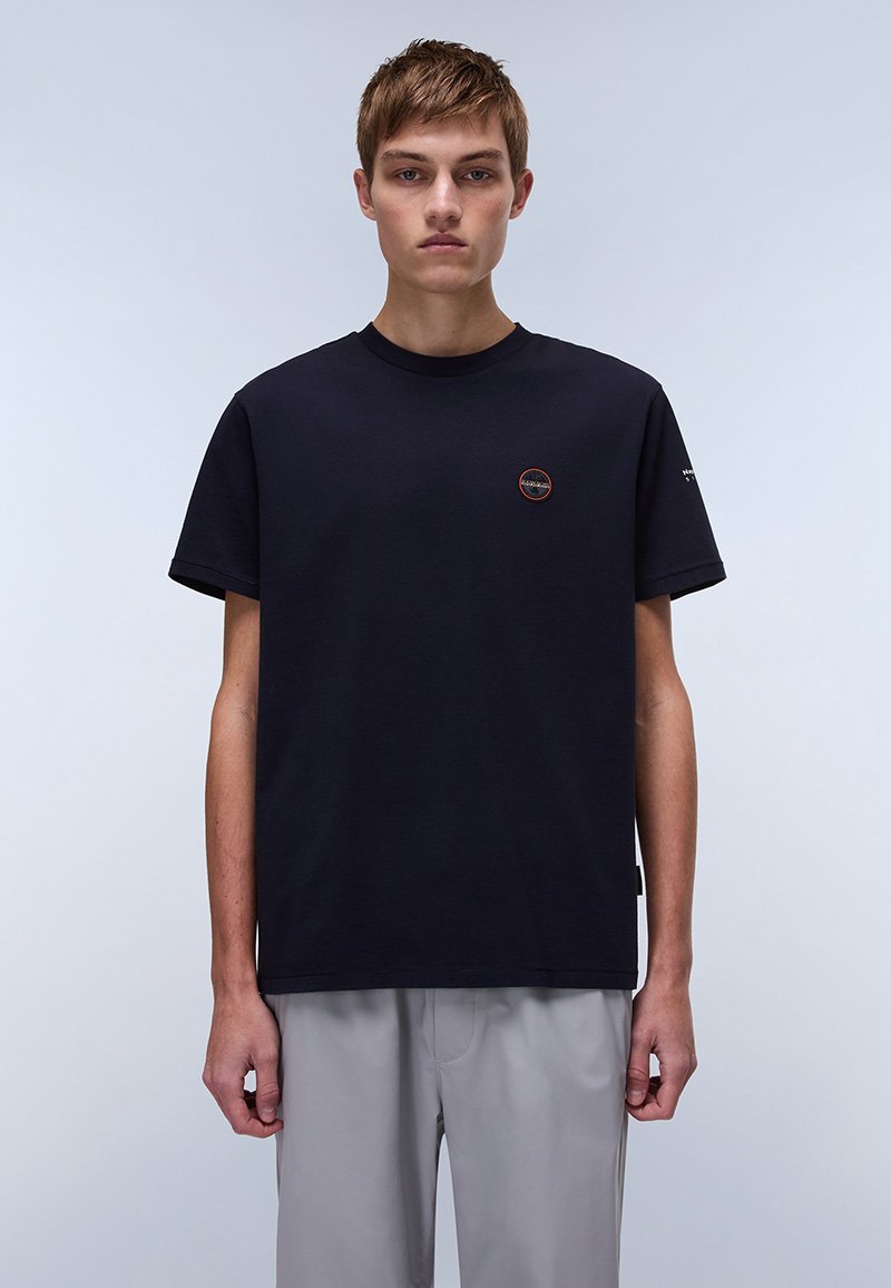 Sort bomulds t-shirt med rund hals, korte ærmer og et lille cirkulært logo på brystet. Afslappet pasform og blød tekstur.
