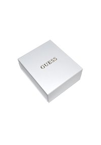 Scatola rettangolare bianca con una superficie texture. Il nome del marchio "GUESS" è stampato in lettere dorate sulla parte superiore.