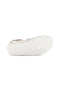 Beige sandaal met twee verstelbare banden en een getextureerde witte rubberen zool, voorzien van een golvend patroon voor grip en comfort.