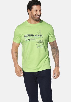 Green cotton t-shirt with short sleeves featuring a sailing graphic and text. Crew neckline, relaxed fit. Worn with dark jeans.