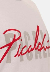 White cotton t-shirt featuring bold red and gray text, with the word "Picahino" prominently displayed in a flowing script style.