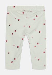 Lys grønne leggings laget av bomull med et gjentatt mønster av marihøner i rødt, rosa og svart. Elastisk midjebånd for komfort.
