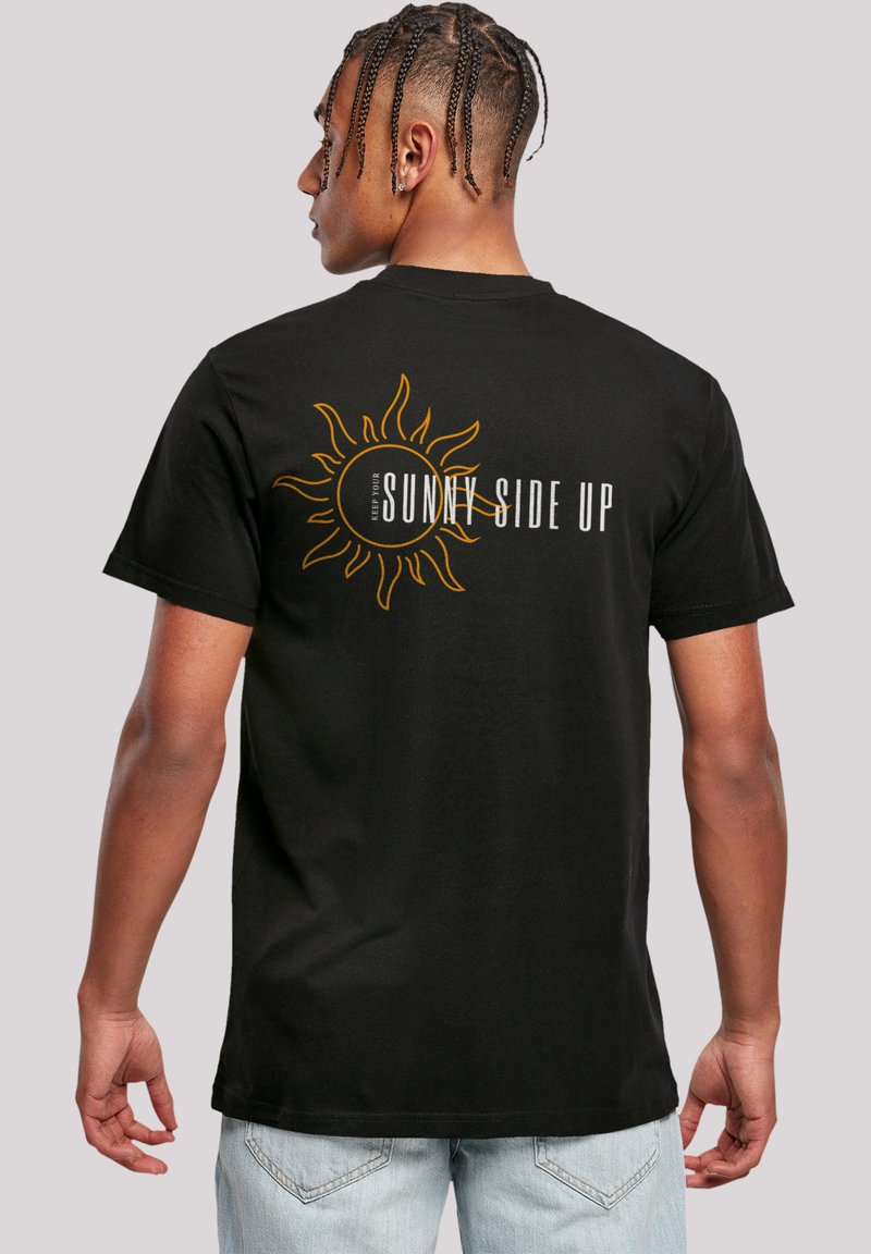 Black cotton t-shirt featuring a yellow sun graphic and "SUNNY SIDE UP" text on the back. Short sleeves, relaxed fit, and classic crew neck.