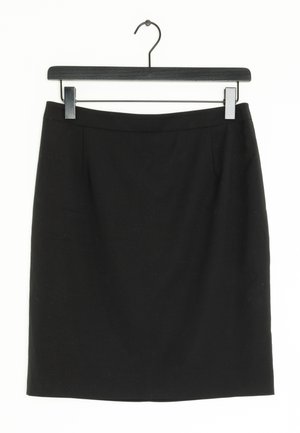 Jupe noire mi-longue droite, suspendue à un cintre noir sur un fond blanc.