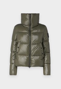 Giacca imbottita verde oliva con collo alto, cerniera frontale e due tasche laterali. Presenta sezioni trapuntate e una toppa con logo nero sulla manica.