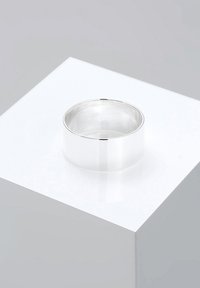 Silver metal ring with a smooth, polished finish. The design is wide and cylindrical, featuring a subtle flat band detail.