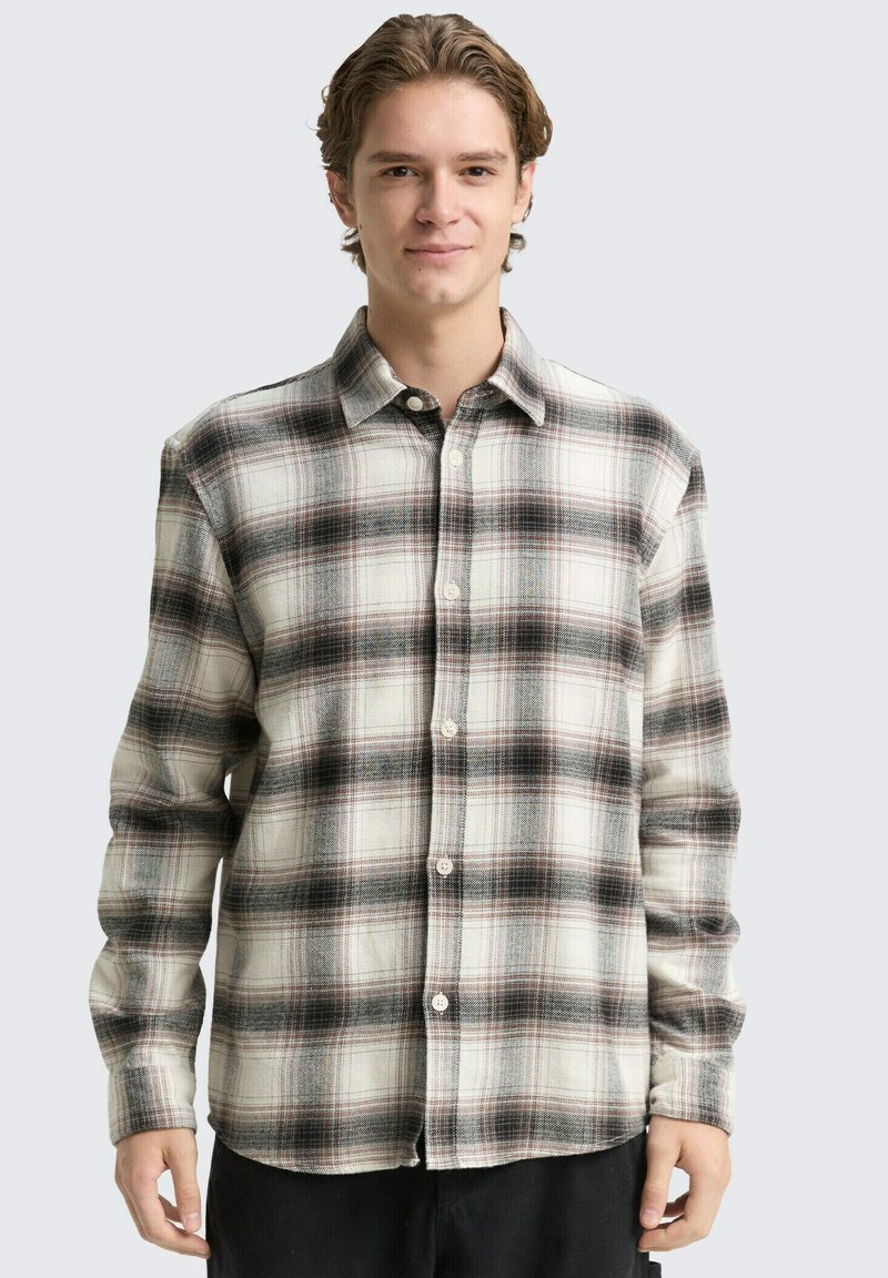 Kariertes Flanellhemd in Creme-, Schwarz- und Rottönen; Knopfdesign; lange Ärmel; weiche Textur; abgerundeter Saum auf Taillenhöhe.