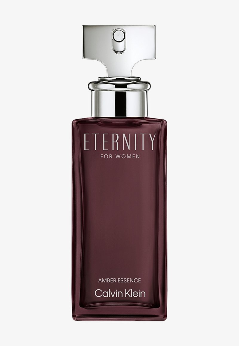 Flacon de parfum rectangulaire en ambre foncé avec pulvérisateur argenté étiqueté "Eternity for Women Amber Essence Calvin Klein."