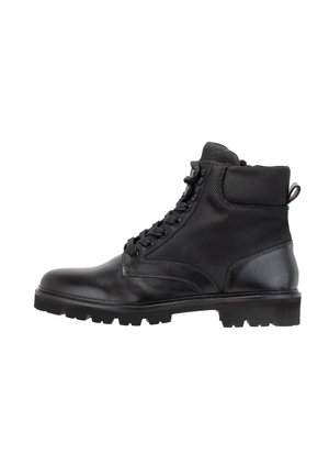 Botines de cuero negro y malla con puntera redonda, parte frontal con cordones, cuello acolchado y suela de goma texturizada. Presenta una pestaña en el talón.