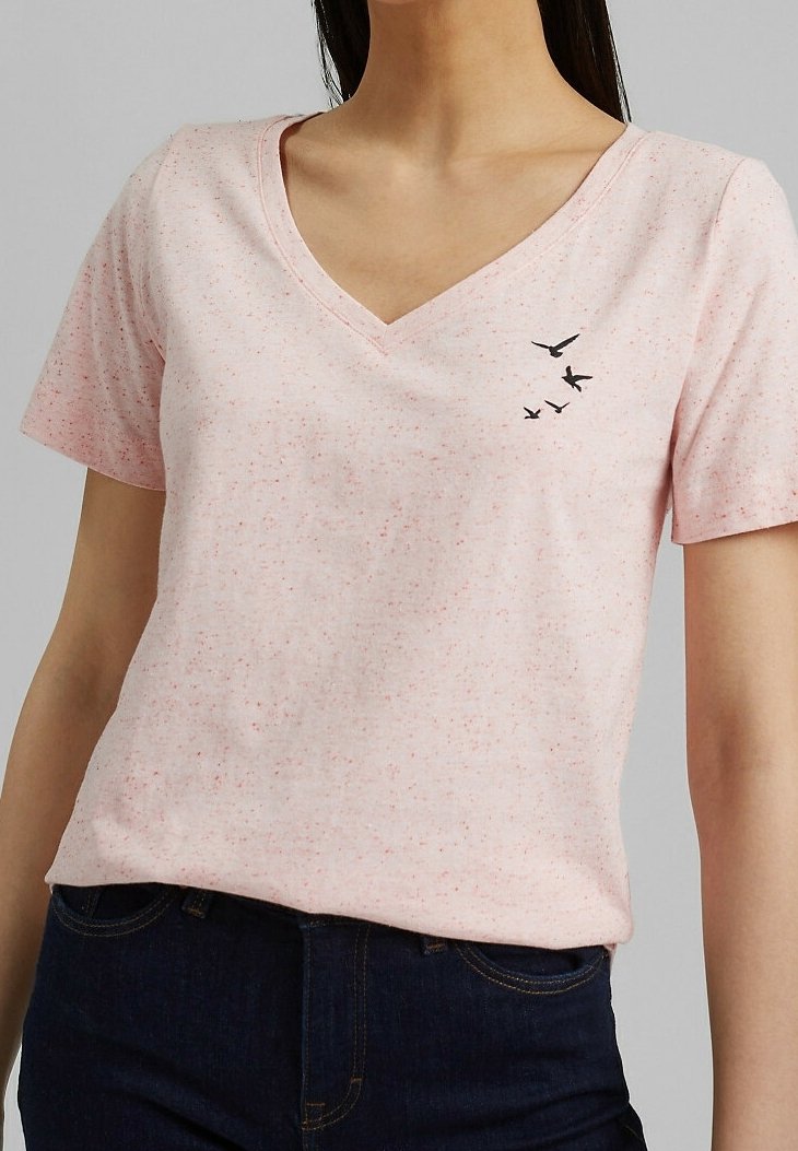 Camiseta de algodón rosa con manchas, de cuello en V y mangas cortas. Presenta un pequeño gráfico de un pájaro negro en el área del pecho izquierdo.