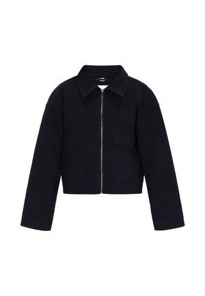 Geknipte zwarte jas met een rits aan de voorkant, puntkraag en twee borstzakken. Gladde textuur met een gestructureerde pasvorm en iets oversized mouwen.