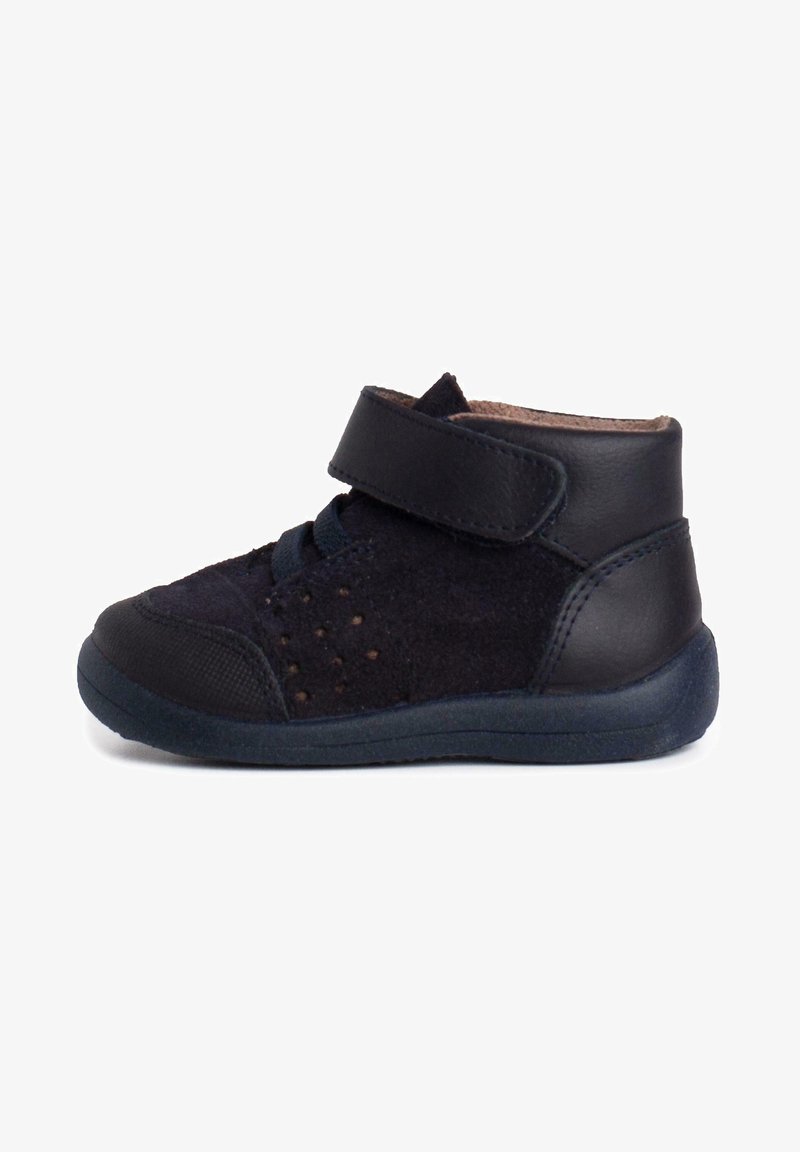 Bottine pour enfants en suède noir avec une sangle en cuir, bout rond, détails perforés et semelle en caoutchouc texturée pour une meilleure accroche et flexibilité.