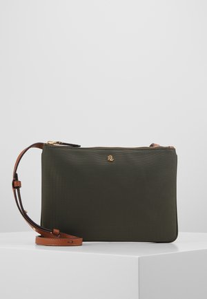Sac bandoulière rectangulaire vert avec fermeture éclair dorée et sangle en cuir marron réglable, présenté sur une surface blanche sur fond gris.
