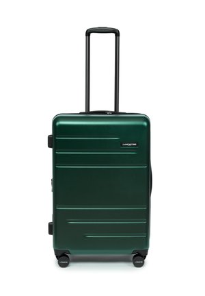 Valise rigide verticale vert foncé avec quatre roues et poignée télescopique noire étendue, logo de la marque Lancaster à l'avant.