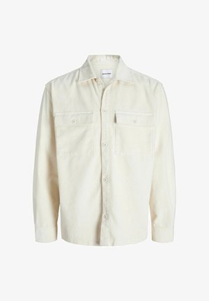 Chemise en velours côtelé écru à manches longues avec fermeture à boutons et deux poches à rabat sur la poitrine avec boutons.