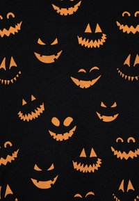 Čierna látka s rôznymi oranžovými dýňovými tvárami jack-o'-lantern, ktoré majú veselý a hrozivý výraz, zobrazujúca rôzne tvary a vzory.