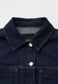 Giacca di denim blu scuro con collo a camicia, cuciture arancioni visibili e bottoni a pressione in argento. Presenta tasche sul petto e un design classico.
