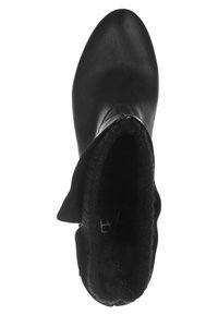 Czarny botek do kostki z gładką skórzaną powierzchnią, zaokrąglonym noskiem i miękkim futrzanym wnętrzem. Górna krawędź ma delikatne załamanie, które podkreśla jego design.
