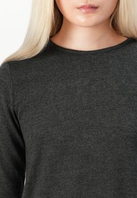 Σκοτεινό γκρι μακρυμάνικο πουκάμισο με στρογγυλή λαιμόκοψη, κατασκευασμένο από μαλακό πλεκτό ύφασμα που διαθέτει απαλό φινίρισμα και ήπια ελαστικότητα.