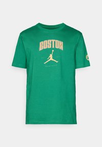 Camiseta de algodón verde con un estampado amarillo de "BOSTON" y una silueta de un jugador saltando. Mangas cortas y cuello redondo, con un logotipo en la manga.